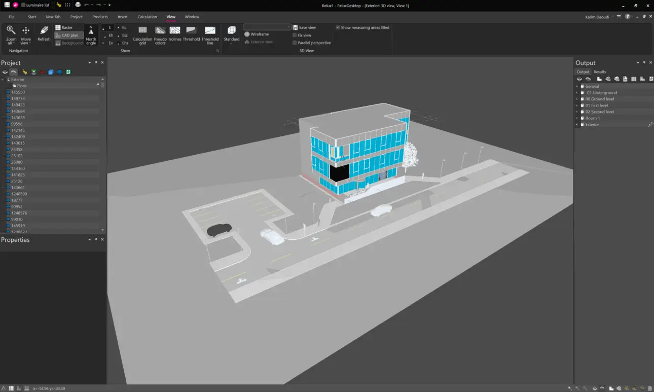 Full application window view of ReluxDesktop's main 3D canvas displaying an imported multi-storey office building model with surrounding parking lots, streets, and sidewalk geometry under a daylight sky simulation.